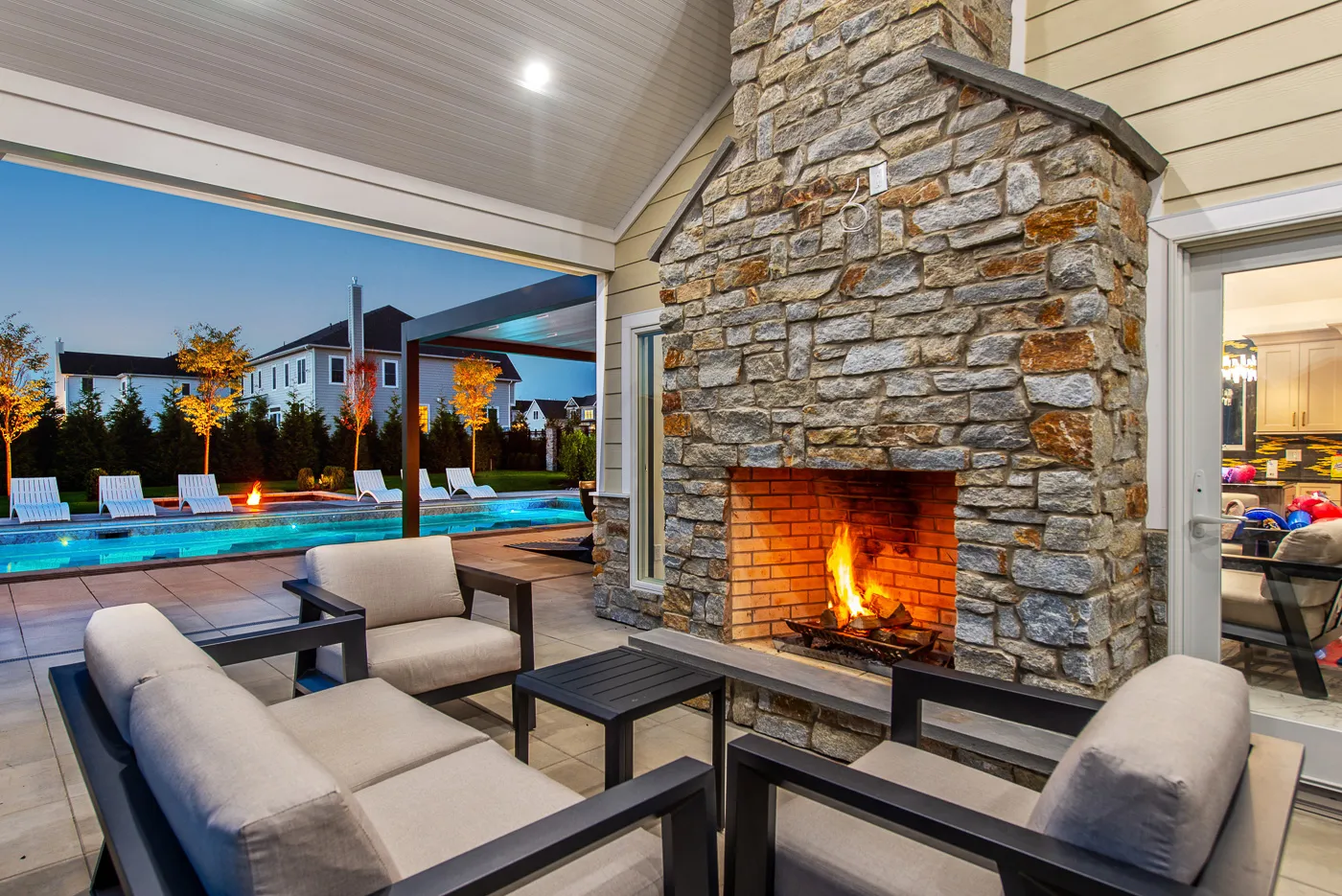 Stone outdoor fireplace beside a pool
