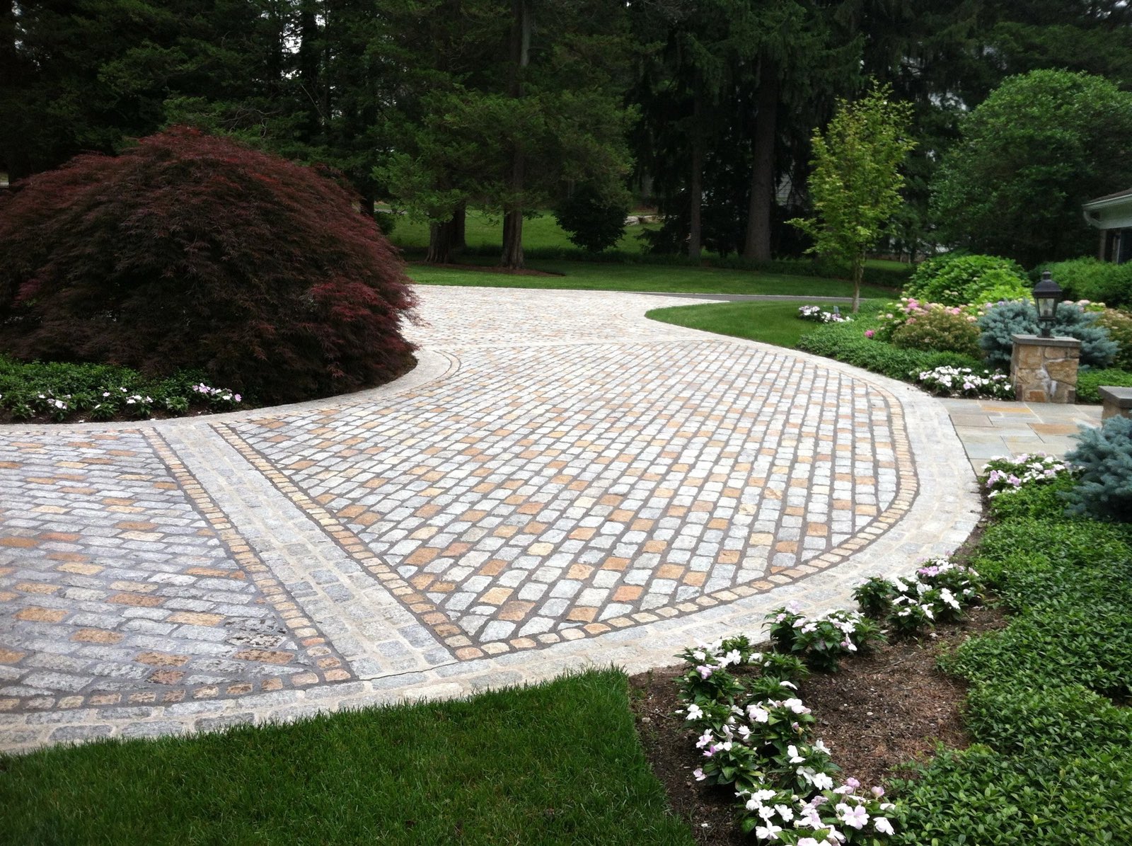 Circular cobblestone court with a radial field and banded paver borders